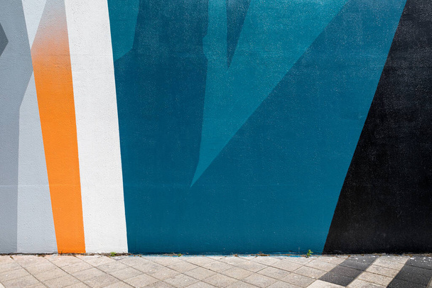 αστική σκηνή με άδειο δρόμο και πολύχρωμο γεωμετρικό τοίχο - Φωτογραφία, εικόνα
