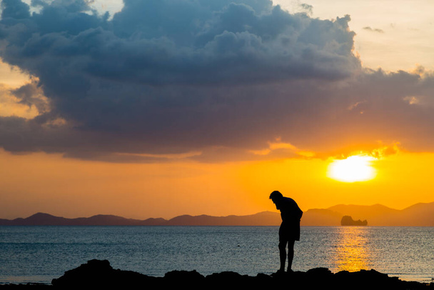 Siluate lonely man at the beach before sunset background - 写真・画像