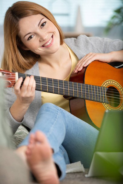 happy girl plays guitar at home - Fotó, kép