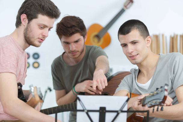 young men hand playing guitar at home - Foto, Imagem