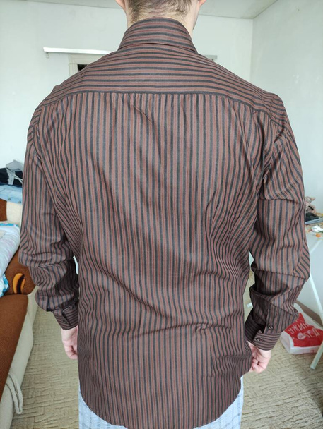 Man tries on the shirt at home - Photo, Image
