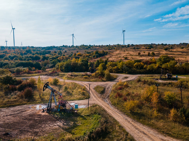 Ölpumpe mit Windkraftanlage grüne Energie mit fossilen Ressourcen - Foto, Bild