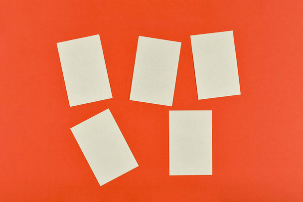 Viisi tyhjää tahmea muistiinpanoja punaisella paperilla tausta tai aluksella - Valokuva, kuva