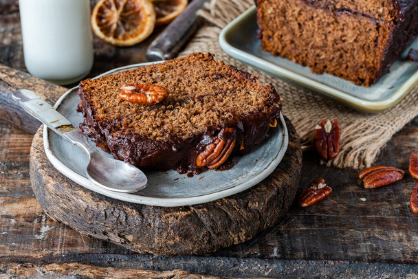 Homemade ginger loaf cake with plum marmalade, pecan nuts and chocolate ganache - Foto, afbeelding