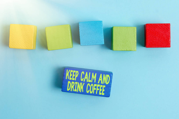 Conceptual display Keep Calm And Drink Coffee. Business idea encourage person to enjoy caffeine drink and relax Stack of Sample Cube Rectangular Boxes On Surface Polished With Multi-Colour - Photo, image