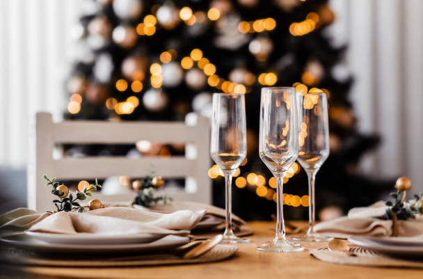 Beautiful set up indoor. Served table with three empty champagne glasses, warm colors, blurred background. Photo - 写真・画像