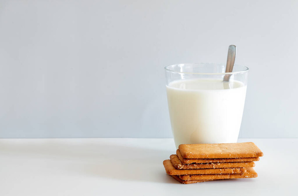 牛乳のガラスと白い背景に5つの長方形のバタービスケットクッキー. - 写真・画像