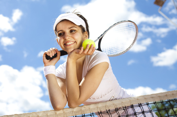 meisje berust op een tennis netto - Foto, afbeelding