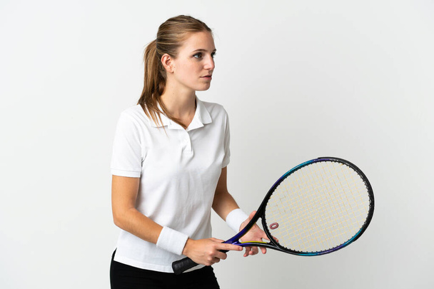 Молодая белая женщина на белом фоне играет в теннис - Фото, изображение