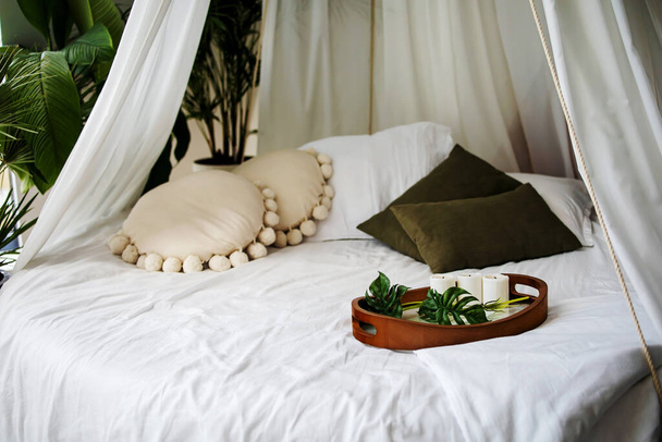 Bohoスタイルのベッドルームインテリア。スタイルのボホールで美しいインテリア。柔らかい枕で眠る - 写真・画像