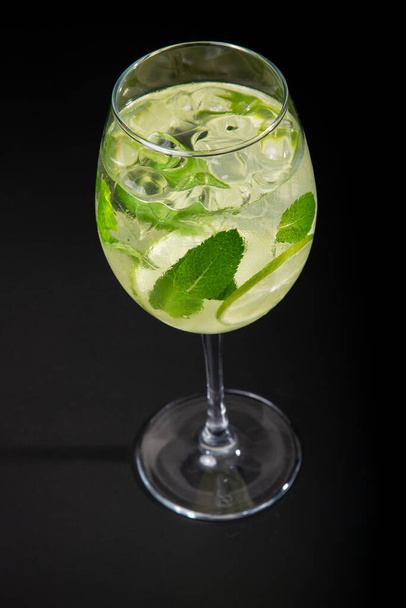 Aperitif is een verfrissende cocktail van limonade gemaakt van citrusschijfjes. Frisdrank met siroop en frisdrank en ijsblokjes. - Foto, afbeelding