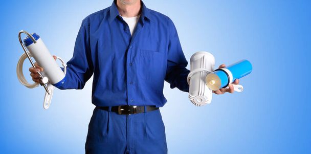 Detail of water treatment technician parts and reverse osmosis supply tools in hands with blue isolated background. Front view. Horizontal composition. - Fotografie, Obrázek