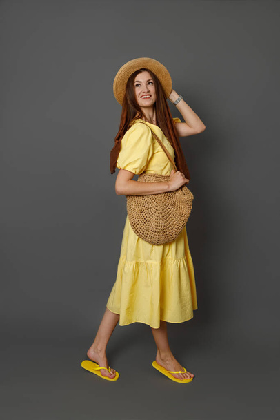 Χαρούμενη όμορφη γυναίκα με καλοκαιρινό φόρεμα στέκεται στο στούντιο - Φωτογραφία, εικόνα