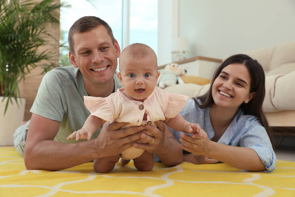 Happy family with their cute baby in living room at home - Valokuva, kuva