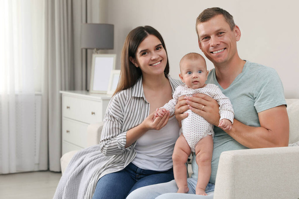 Happy family with their cute baby in living room at home - Fotoğraf, Görsel