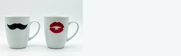 Web Banner από λευκές κεραμικές κούπες διακοσμημένες με μαύρο ανδρικό μουστάκι και κόκκινα γυναικεία χείλη. Ρομαντική ημέρα του Αγίου Βαλεντίνου και έννοια του γάμου. Έρωτας και ρομαντισμός. - Φωτογραφία, εικόνα