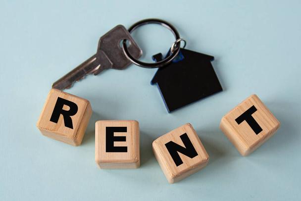 RENT - word on wooden cubes on the background of a key with a keychain house - Фото, изображение