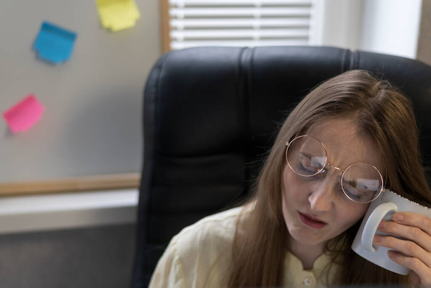Mujer de negocios que sufre de dolor de cabeza mientras está sentada en la oficina. Una jefa atormenta por las migrañas. Trabajador de oficina cansado. - Foto, imagen