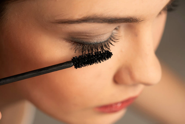 Close up of a woman applies mascara on a white background - Photo, image