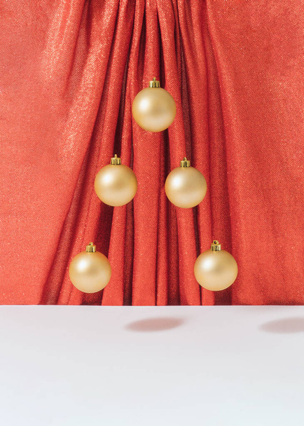 Composition de Noël rétro créative avec décoration en boule d'or contre rideau rouge brillant. Millésime surréaliste Nouvelle année concept. - Photo, image