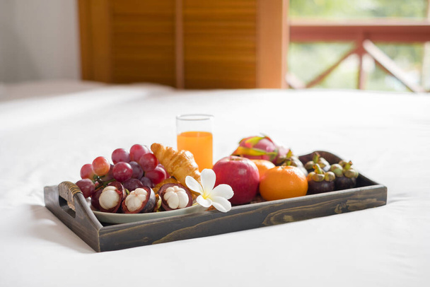 Focus on fruit. In a hotel room with fruit, place a tray on the bed to welcome the arrival of VIP guests. - Photo, image
