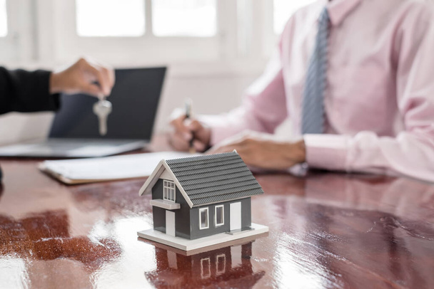 Ingatlan ügynök bróker átadja a ház kulcsát az új tulajdonos befejezése után az aláírás megállapodás szerint bérleti egy házat, és vásárolni ház biztosítás Home insurance koncepció. - Fotó, kép