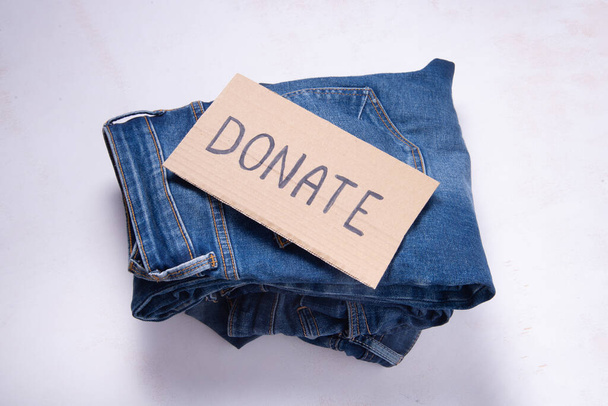 Gebruikte denim jeans voor donatie, teken doneren - Foto, afbeelding