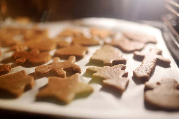 Uncooked gingerbread Christmas cookies on a baking tray in an oven - Photo, Image