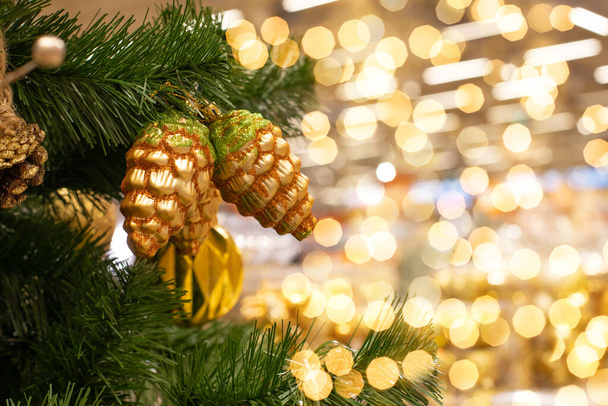 Fundo de Natal espumante, árvore de Natal verde com cones dourados, luzes cintilantes cintilantes cintilantes - Foto, Imagem