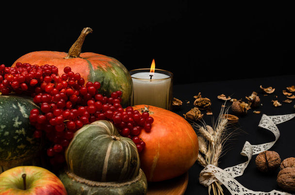 Composición festiva de calabaza de Acción de Gracias con vela sobre fondo negro.  - Foto, imagen