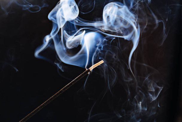 smoke from an aromatic stick on a black background. - Photo, image
