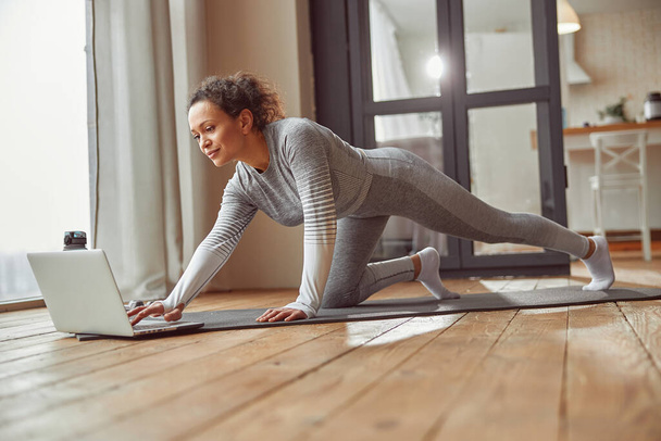 Fröhliche Frau bereitet sich auf Online-Workout zu Hause vor - Foto, Bild
