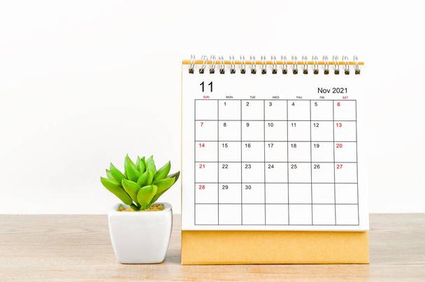 The November desk calendar 2021 with plant pot on wooden background. - Foto, immagini