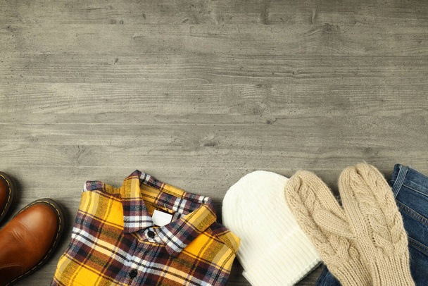 Concept of winter clothes on gray wooden table. - Photo, Image