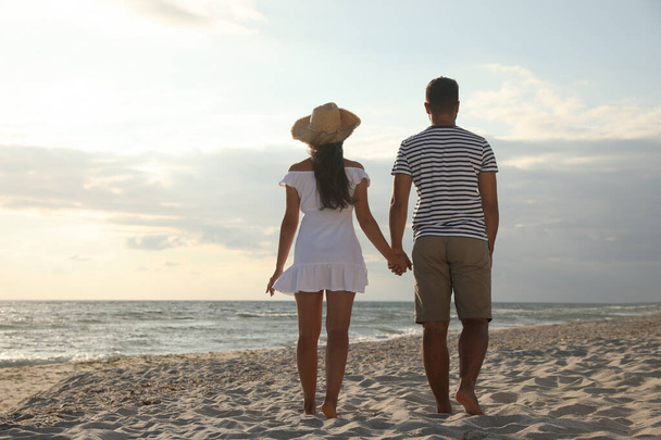 Lovely couple spending time together on beach, back view - Fotoğraf, Görsel
