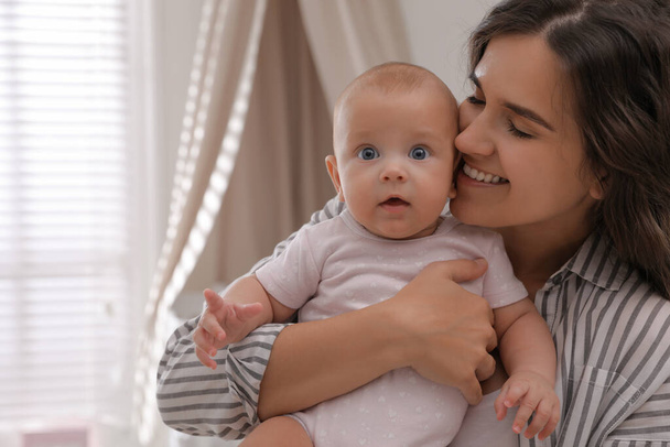 Happy young mother with her cute baby at home - Foto, imagen