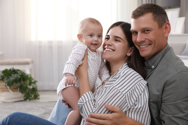 Happy family with their cute baby in living room at home - Foto, immagini