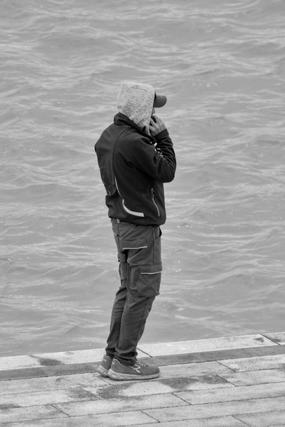 Italien, Sizilien, Mittelmeer, Marina di Ragusa (Provinz Ragusa); Mann am Telefon im Hafen  - Foto, Bild