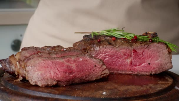 Chef Sprinkling Salt On Beefsteak Carne condimentada en la cocina, Cultivado - Metraje, vídeo