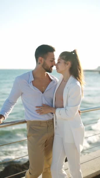 Hispanic couple embracing and kissing against ocean - Footage, Video