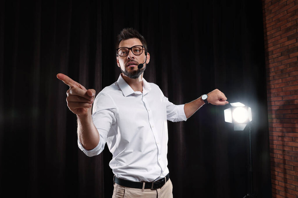 Motivational speaker with headset performing on stage - Foto, afbeelding