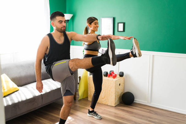 Cvičení HIIT. Hispánský pár dělá kardio cvičení společně v obývacím pokoji - Fotografie, Obrázek