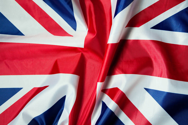 Close-up shot of wavy British flag with fabric texture. - Фото, изображение