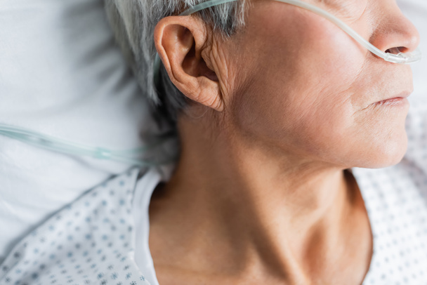 Widok starszego pacjenta z kaniulą nosową leżącego na łóżku w szpitalu  - Zdjęcie, obraz