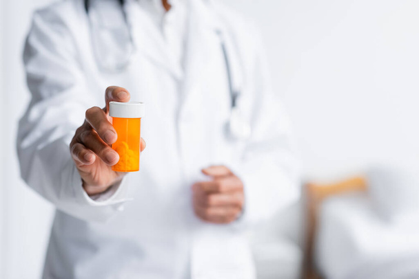 Cropped view of blurred doctor holding pills in hospital  - Foto, immagini