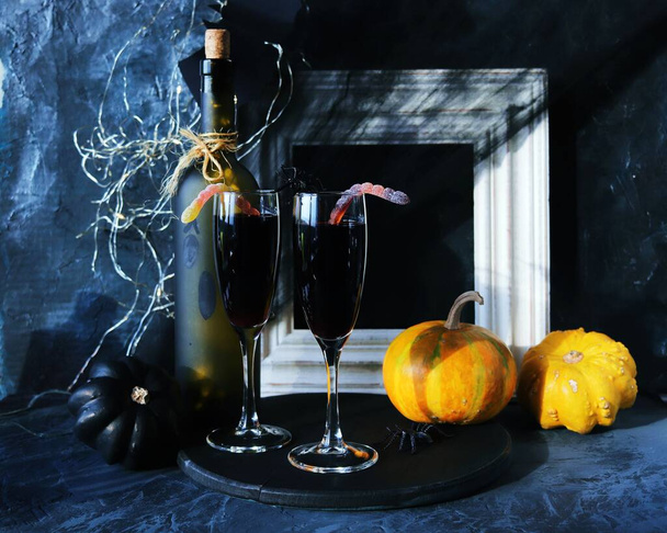 Halloween drinks, wine, pumpkins, mystical decorations, on a black background, the concept of the atmosphere of a party, holiday - Photo, Image