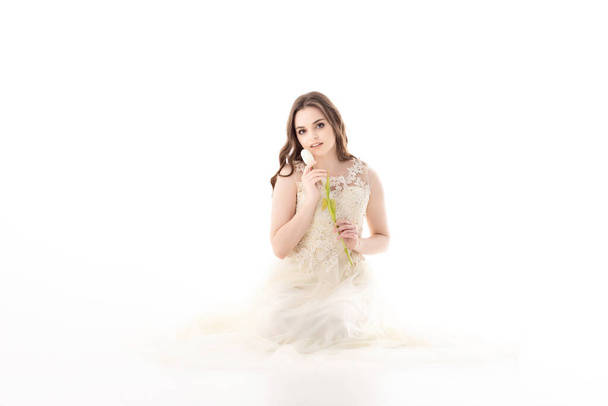 Een vrouw in een witte jurk met een tulp in haar handen - Foto, afbeelding