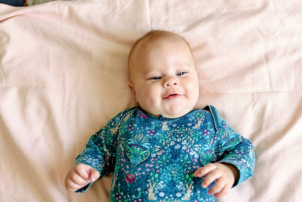 Üç aylık pembe pantolonlu, bezli bir bebek gibi gülümsüyor. Üst görünüm - Fotoğraf, Görsel