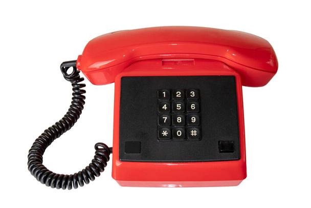 Vintage telecommunication technology. Close-up of a old red telephone with black cable and buttoms. Suitable for contact exchange and call centre. Retro phone receiver. - Foto, immagini