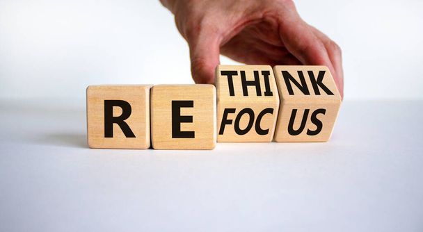 Refocus and rethink symbol. Businessman turns cubes and changes the word 'refocus' to 'rethink'. Beautiful white table, white background. Business refocus and rethink concept. Copy space. - Foto, Imagem